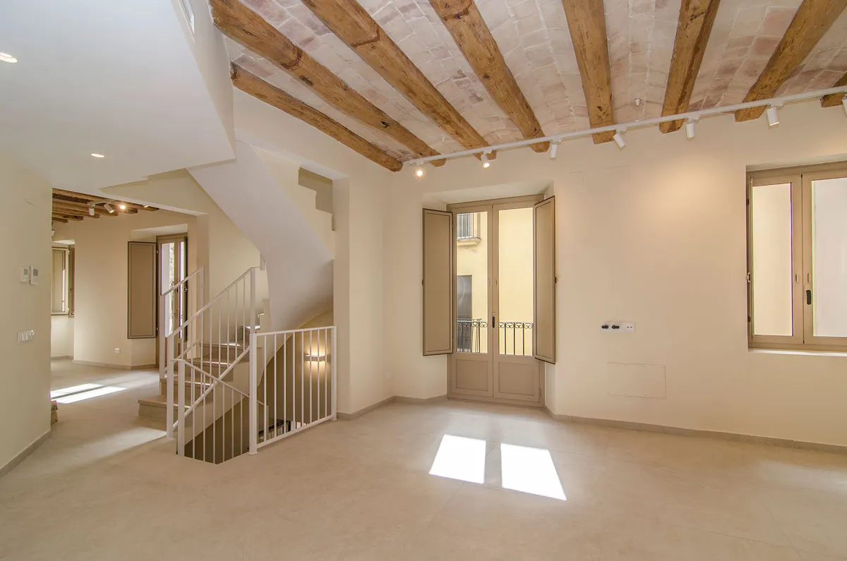 Refurbishment on Carrer Fossar Vell, Vilanova i la Geltrú — living room with wooden beams and shutters