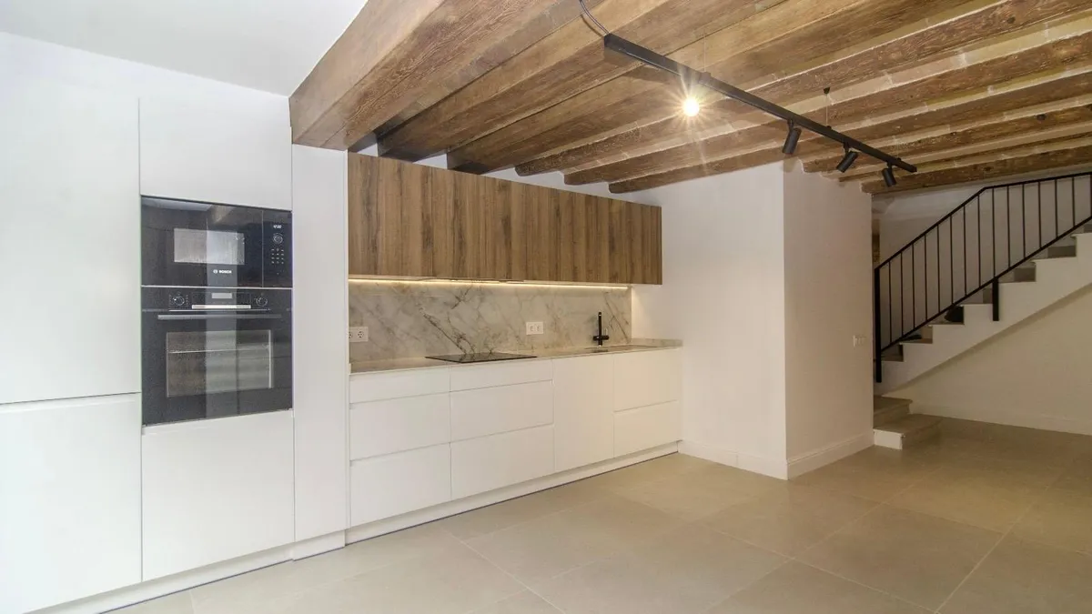 Refurbishment on Carrer Major, Vilanova i la Geltrú — kitchen with a Catalan vault and wooden beams